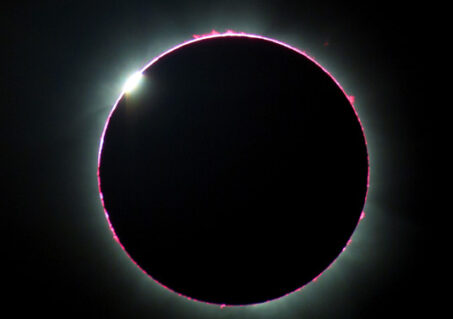 A very short (13-second) totality reveals the red chromosphere almost completely encircling the Moon at second contact.  (Photo by Judy Anderson)