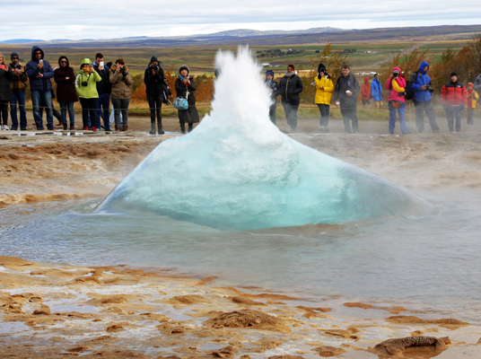TravelQuest travelers watch a hot-water geyser erupt on our aurora excursion to Iceland. (Photo by Paul Deans/TQ)